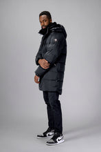 Load image into Gallery viewer, Woodpecker Men&#39;s Penguin Long Winter coat. High-end Canadian designer winter coat for men in &quot;Black Diamond&quot; colour. Woodpecker cruelty-free winter coat designed in Canada. Men&#39;s heavy weight long length premium designer jacket for winter. Superior quality warm winter coat for men. Moose Knuckles, Canada Goose, Mackage, Montcler, Will Poho, Willbird, Nic Bayley. Extra warm. Shiny parka. Stylish winter jacket. Designer winter coat.
